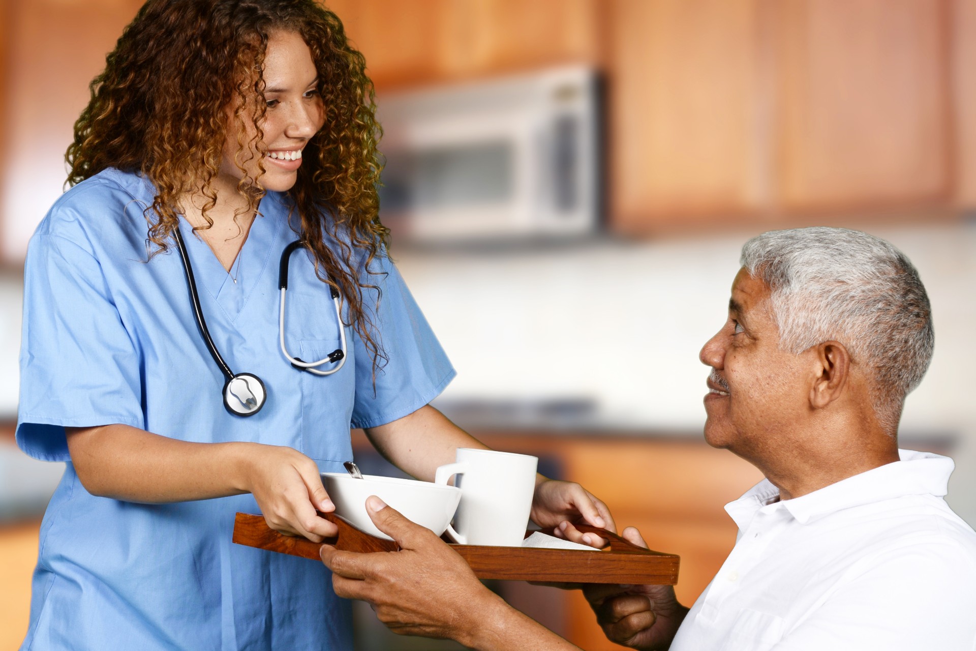 Nurse serving food to elderly man